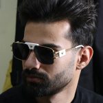 عکس از عینک آفتابی ورساچه با فریم شکل چند ضلعی و لنز تیره مدل 22206 بر روی صورت محمدحسین ابراهیم زاده