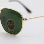 عکس از عینک آفتابی Ray-Ban با فریم رنگ طلایی، شکل چندضلعی و لنز سبز تیره و جنس سنگ مدل RB3548