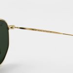 عکس از عینک آفتابی Ray-Ban با فریم رنگ طلایی، شکل چندضلعی و لنز سبز تیره و جنس سنگ مدل RB3548