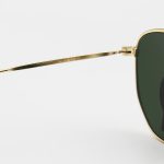 عکس از عینک آفتابی Ray-Ban با فریم رنگ طلایی، شکل چندضلعی و لنز سبز تیره و جنس سنگ مدل RB3548