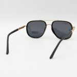 عکس از عینک آفتابی Ray-Ban با فریم مشکی و طلایی، شکل چند ضلعی، دسته فنری و لنز دودی تیره و پلاریزه مدل P9004
