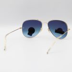 عکس از عینک آفتابی Ray-Ban با فریم خلبانی، رنگ طلایی، لنز از جنس سنگ، آبی تیره و هایلایت مدل RB3026 HQ