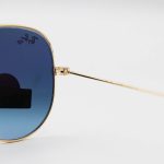 عکس از عینک آفتابی Ray-Ban با فریم خلبانی، رنگ طلایی، لنز از جنس سنگ، آبی تیره و هایلایت مدل RB3026 HQ