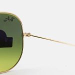 عکس از عینک آفتابی Ray-Ban با فریم خلبانی، رنگ طلایی، لنز سنگ و سبز تیره و سایه روشن مدل RB3026 HQ