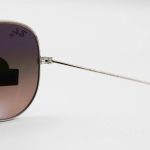 عکس از عینک آفتابی Ray-Ban با فریم خلبانی، رنگ نقرهای، لنز سنگ و قهوهای تیره و هایلایت مدل RB3026 HQ