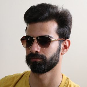 عکس از عینک آفتابی CARTIER با فریم شکل خلبانی و دسته طرح چوبی مدل P1002 بر روی صورت محمدحسین ابراهیم زاده