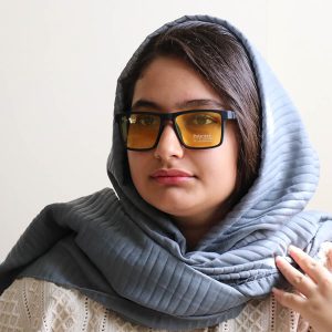 عکس از عینک دید در شب Cartier با فریم مستطیلی شکل، رنگ مشکی مات و عدسی زرد رنگ مدل P21170 بر روی صورت فاطمه ابراهیم زاده