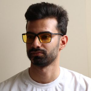 عکس از عینک دید در شب پورشه دیزاین با فریم مستطیلی شکل، رنگ مشکی مات و لنز زرد رنگ مدل Y151 بر روی صورت محمدحسین ابراهیم زاده