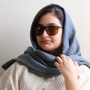 عکس از عینک شب اوگا مورل با فریم مشکی مات، مستطیلی شکل، بیس‌دار و دسته فنری و لنز زرد رنگ مدل 78019 بر روی صورت فاطمه ابراهیم زاده