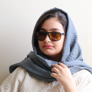 عکس از عینک شب اوگا مورل با فریم مشکی مات، مستطیلی شکل، بیس‌دار و دسته فنری و لنز زرد رنگ مدل 78022 بر روی صورت فاطمه ابراهیم زاده