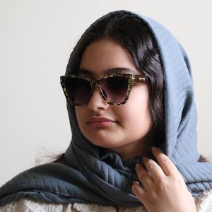 عکس از عینک آفتابی زنانه تام فورد با فریم شکل گربه‌ای، رنگ سوسماری (زرد و مشکی) و لنز دودی سایه روشن مدل 7266 بر روی صورت فاطمه ابراهیم زاده