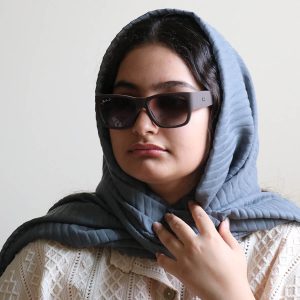 عکس از عینک آفتابی Ray-Ban با فریم قهوه ای مات، شکل مستطیلی، دسته پهن و لنز پلاریزه و قهوه‌ای هایلایت مدل RB2187 بر روی صورت فاطمه ابراهیم زاده