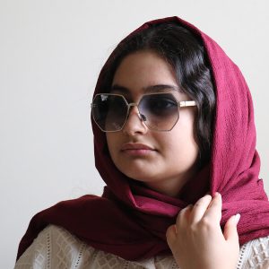 عکس از عینک آفتابی IC! BERLIN با فریم چندضلعی، از جنس تیتانیوم و لنز هایلایت مدل PS18034 بر روی صورت فاطمه ابراهیم زاده
