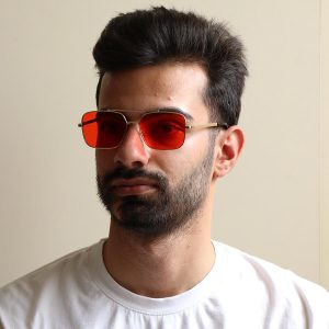 عکس از عینک دید در شب Ditiai با فریم فلزی، رنگ طلایی، مستطیلی شکل و عدسی قرمز رنگ مدل 9546 بر روی صورت محمدحسین ابراهیم زاده