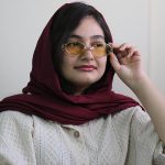 عکس از عینک دید در شب جنتل مانستر با فریم طلایی رنگ، بیضی شکل و دسته مشکی و لنز زرد رنگ مدل B2069 بر روی صورت فاطمه ابراهیم زاده