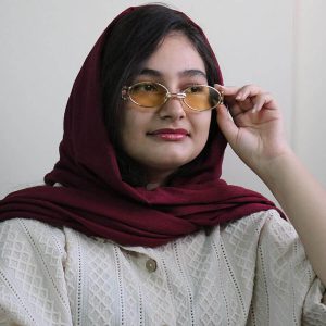 عکس از عینک دید در شب جنتل مانستر با فریم طلایی رنگ، بیضی شکل و دسته مشکی و لنز زرد رنگ مدل B2069 بر روی صورت فاطمه ابراهیم زاده