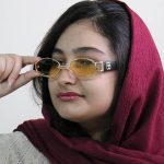 عکس از عینک دید در شب جنتل مانستر با فریم طلایی رنگ، بیضی شکل و دسته مشکی و لنز زرد رنگ مدل B2069 بر روی صورت فاطمه ابراهیم زاده