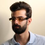 عکس از عینک دید در شب جنتل مانستر با فریم طلایی رنگ، بیضی شکل و دسته مشکی و لنز زرد رنگ مدل B2069 بر روی صورت محمدحسین ابراهیم زاده