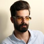 عکس از عینک دید در شب جنتل مانستر با فریم طلایی رنگ، بیضی شکل و دسته مشکی و لنز زرد رنگ مدل B2069 بر روی صورت محمدحسین ابراهیم زاده