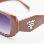 عکس از عینک آفتابی PRADA با فریم مستطیلی شکل، رنگ قهوهای تیره و لنز دودی سایه روشن مدل N3941